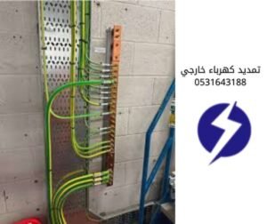 لوحة توزيع كهربائية مع أسلاك تأريض (أرضي) خضراء وصفراء متصلة بقضيب نحاسي.